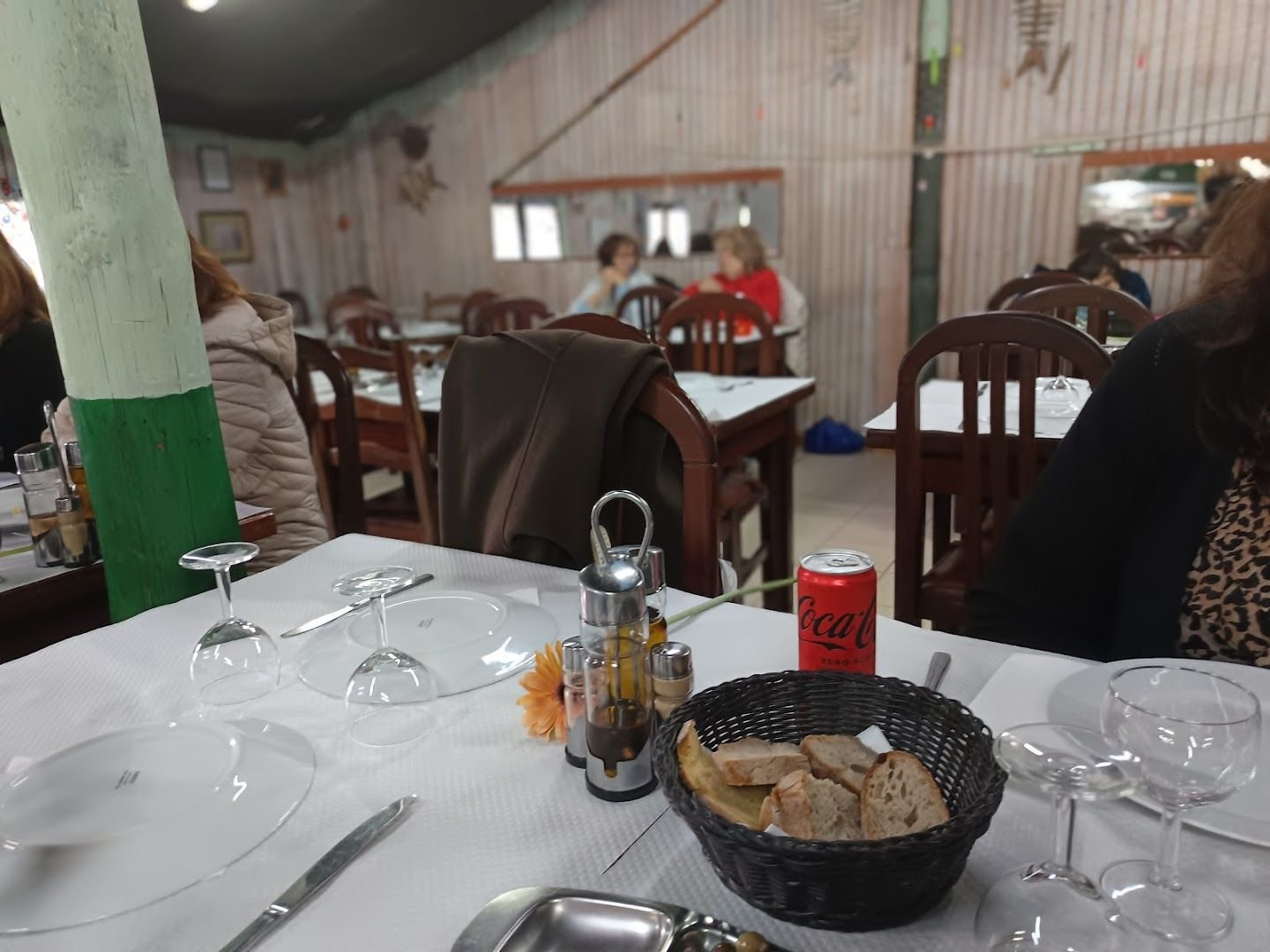 Interior da cabana com mesas postas e paredes de chapa